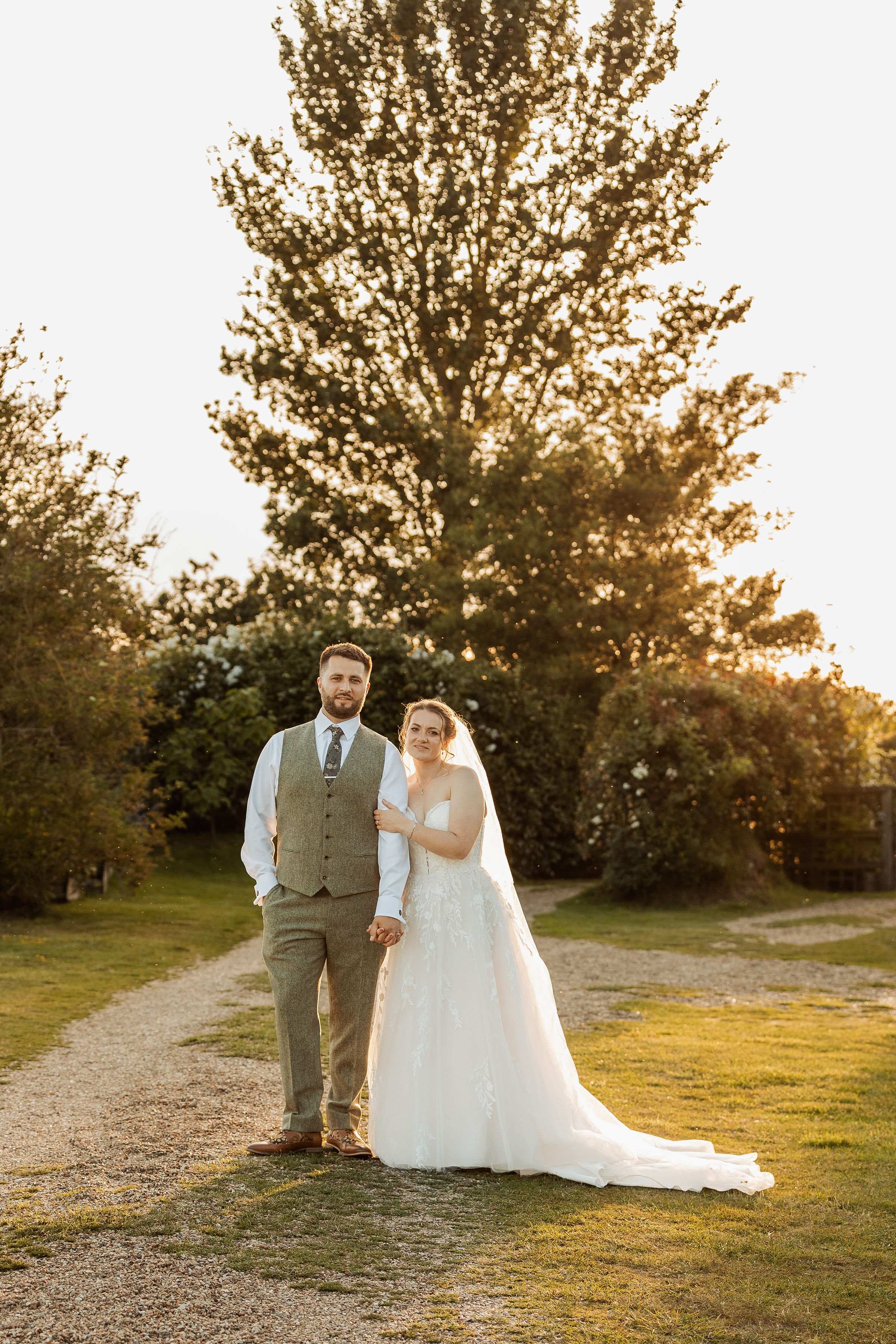 Harry and Rachel standing together beneath trees at The Oak Grove