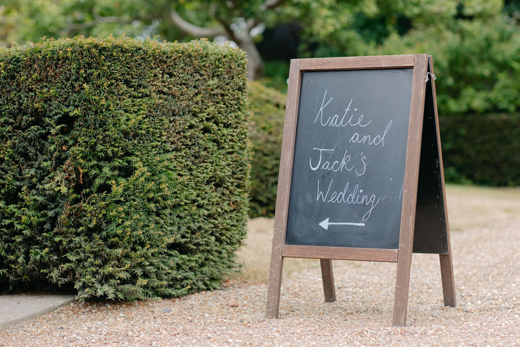 Katie and Jack’s wedding welcome sign beside the garden hedge