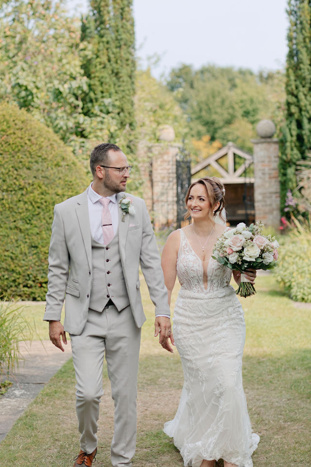 Jack and Katie walking hand in hand through the gardens