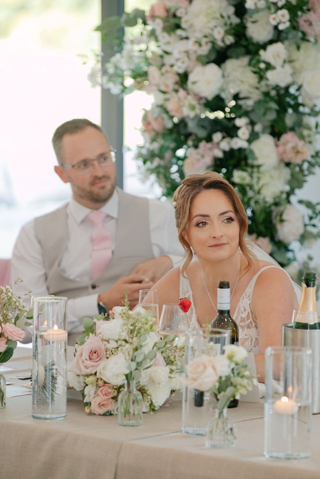 Jack and Katie seated together at their wedding reception