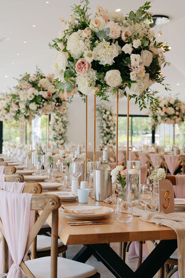 Pink and white flowers arranged above the wedding reception tables